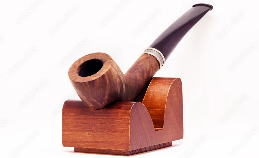 Fajka na tabak položená v drevenom stojane na fajku